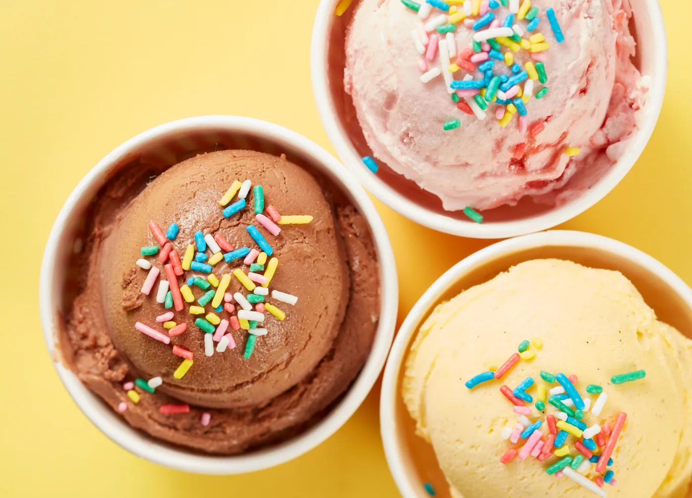 Trois pots de glace, chocolat, fraise et vanille, avec vermicelles